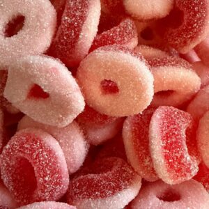 Mini sour strawberry ring sweets with red colour and tangy sugar coating in pick n mix